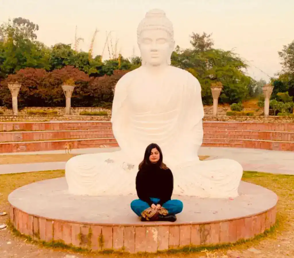 A girl is sitting in a meditative pose just like Gautam Buddha is at the Garden of Silence in Chandigarh.